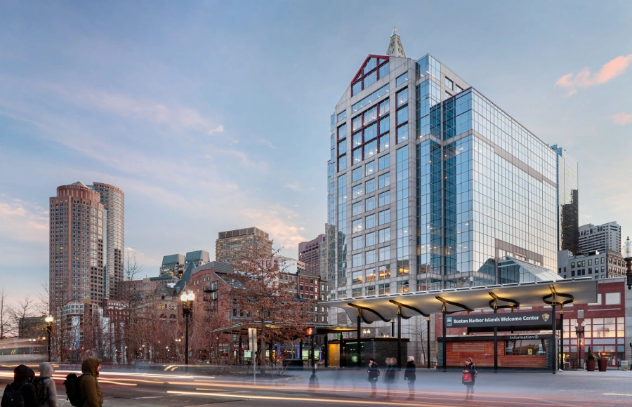 Urban Boston office tower with reflective windows and harbor welcome center entrance