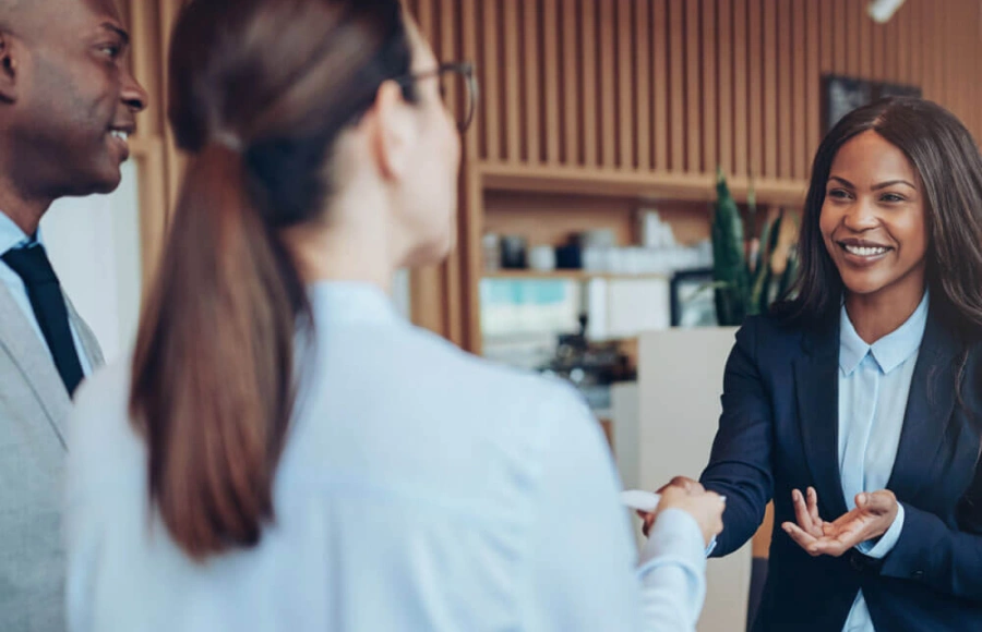 Smiling businesswoman accepting business card during professional meeting in modern office setting