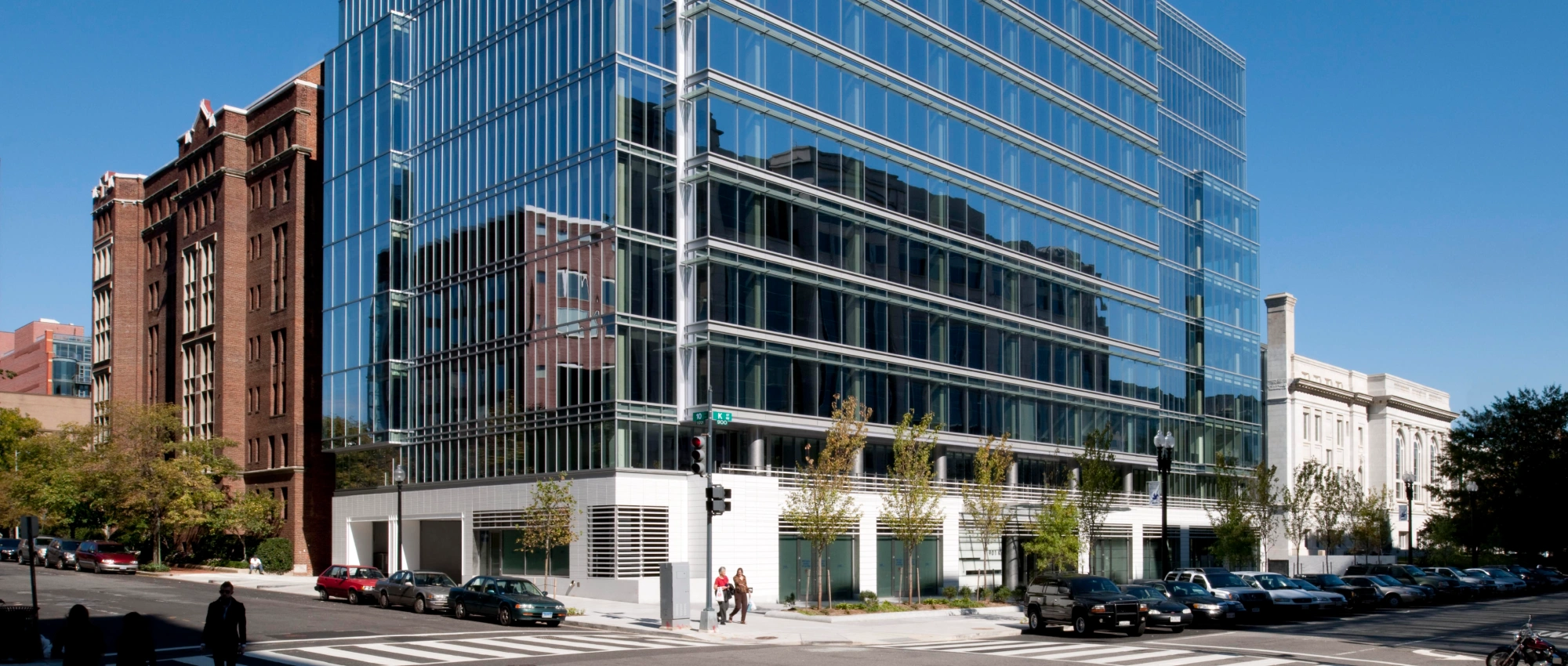 Contemporary commercial architecture featuring a multi story glass tower alongside historic neighboring buildings