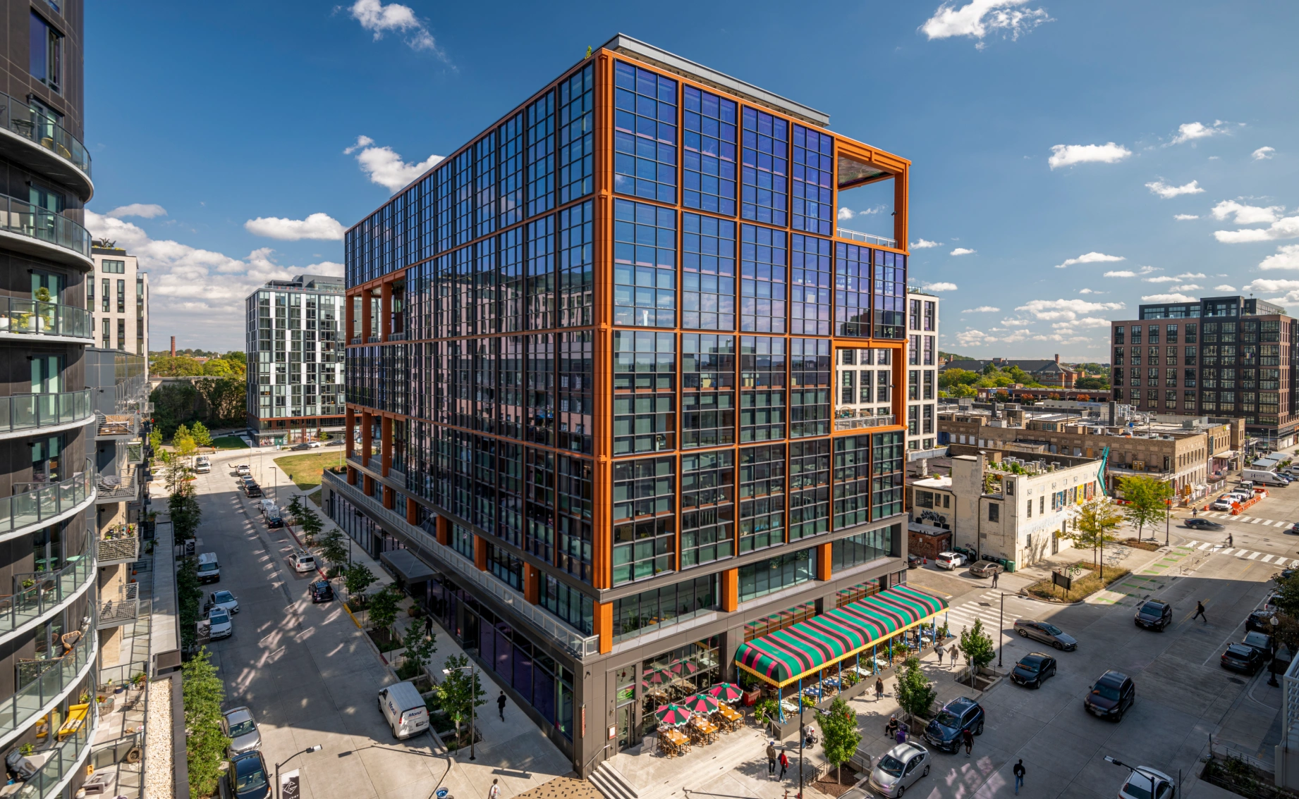 Contemporary mixed use office tower showcasing expansive windows urban intersection and outdoor dining