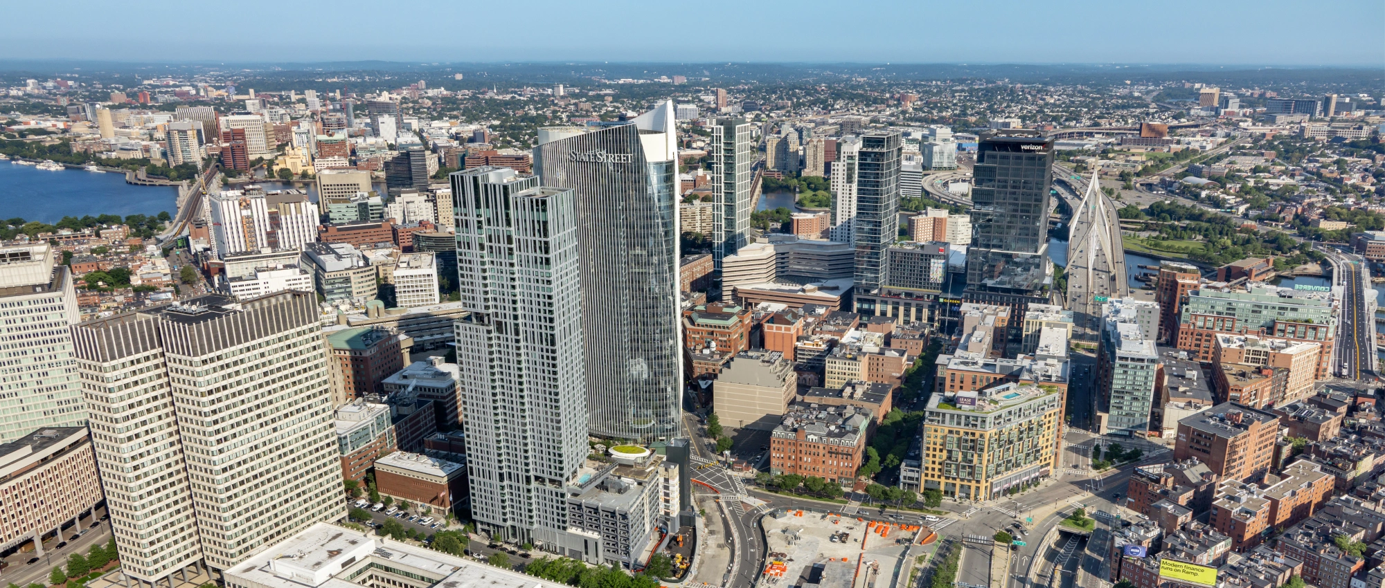 Expansive urban aerial showcasing dense city core glass skyscrapers highways and surrounding neighborhoods