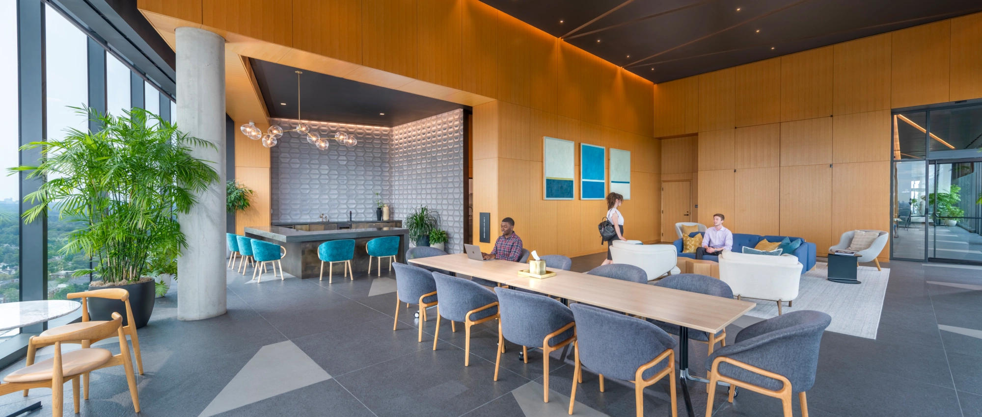 Upscale apartment common area combining social lounge coworking table stylish lighting and indoor plants