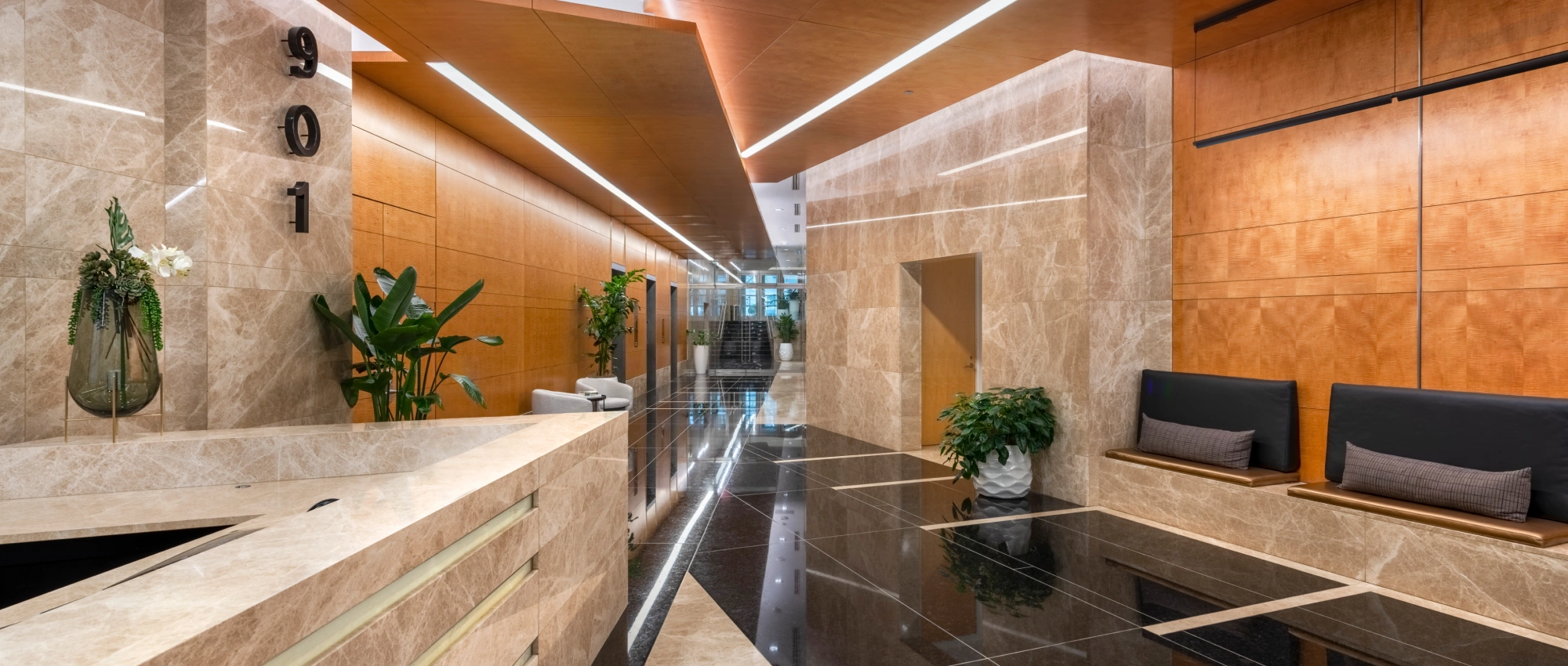 Modern office building reception showcasing polished stone floors natural wood walls and minimalist décor
