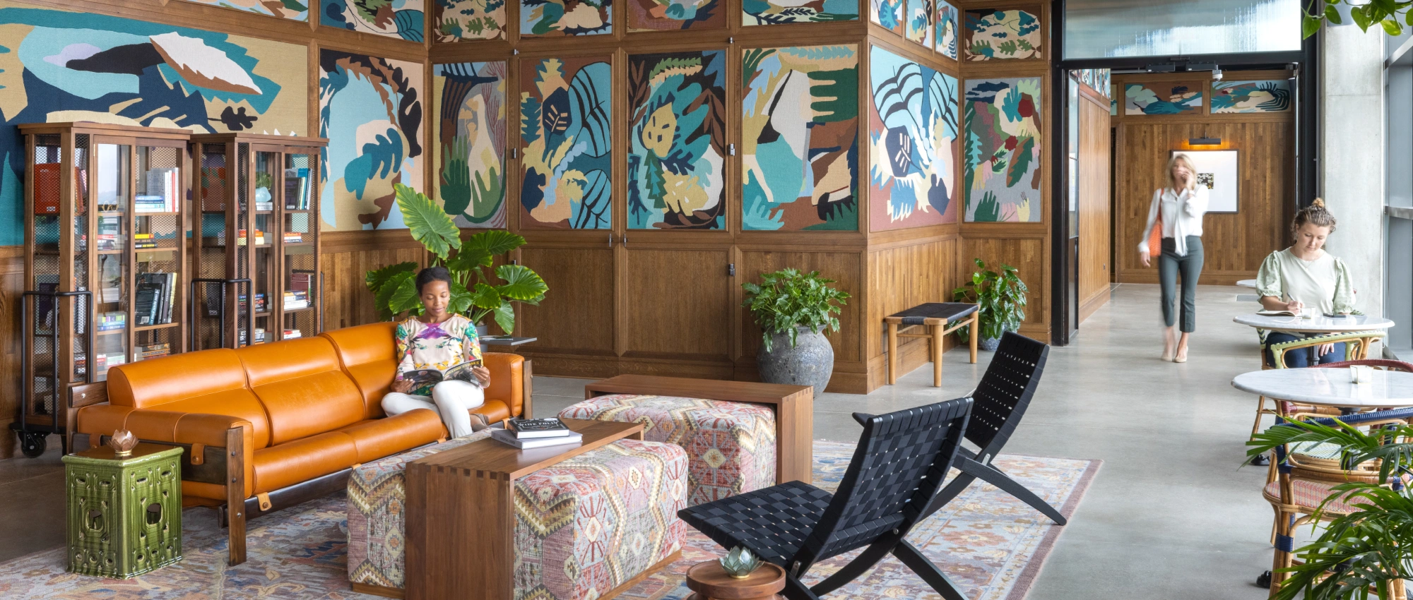 Stylish communal living space featuring a leather sofa, patterned textiles, curated books, and natural light for everyday comfort
