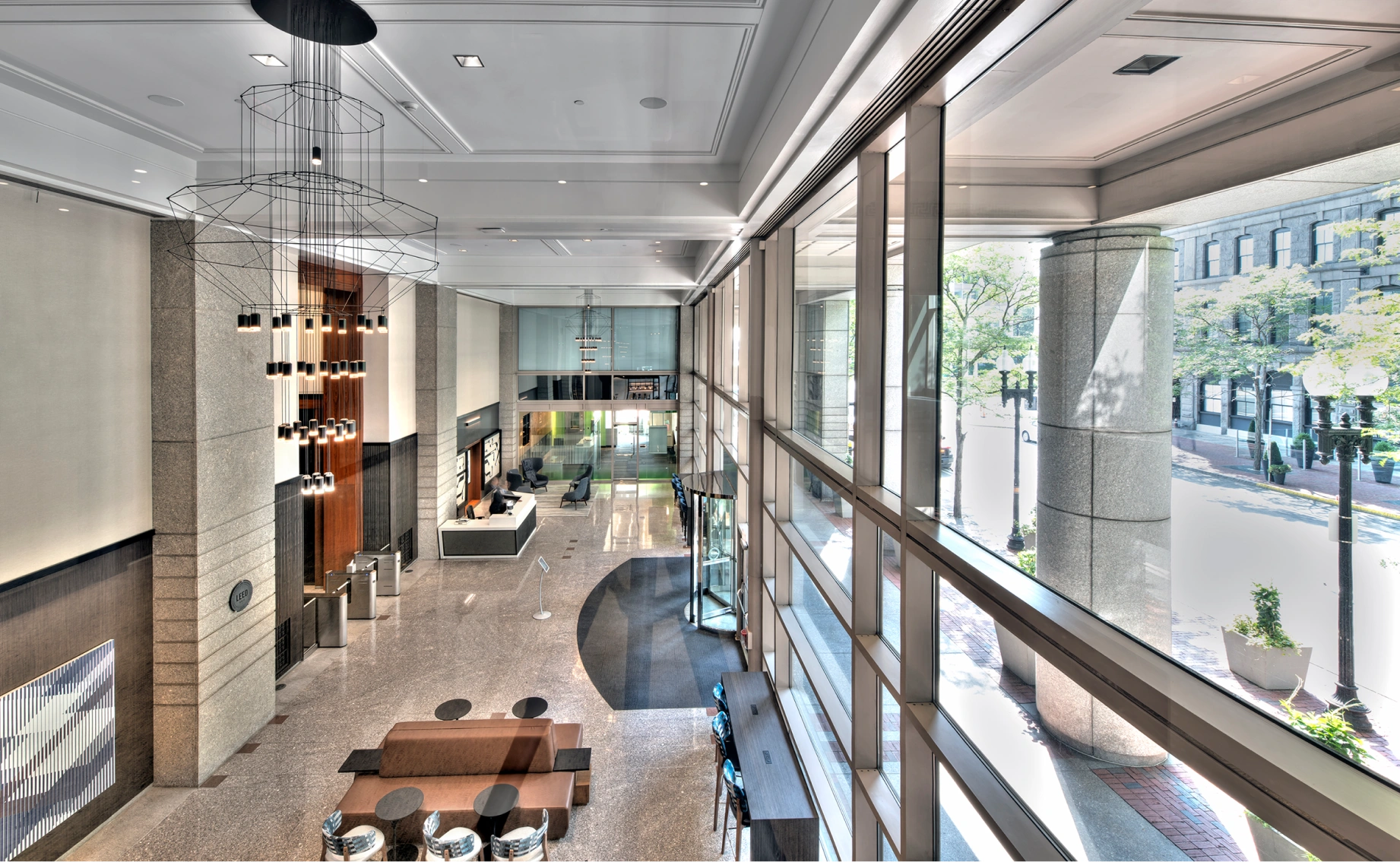 Elegant corporate atrium showcasing high ceilings, natural light, polished stone floors, and stylish reception lounge