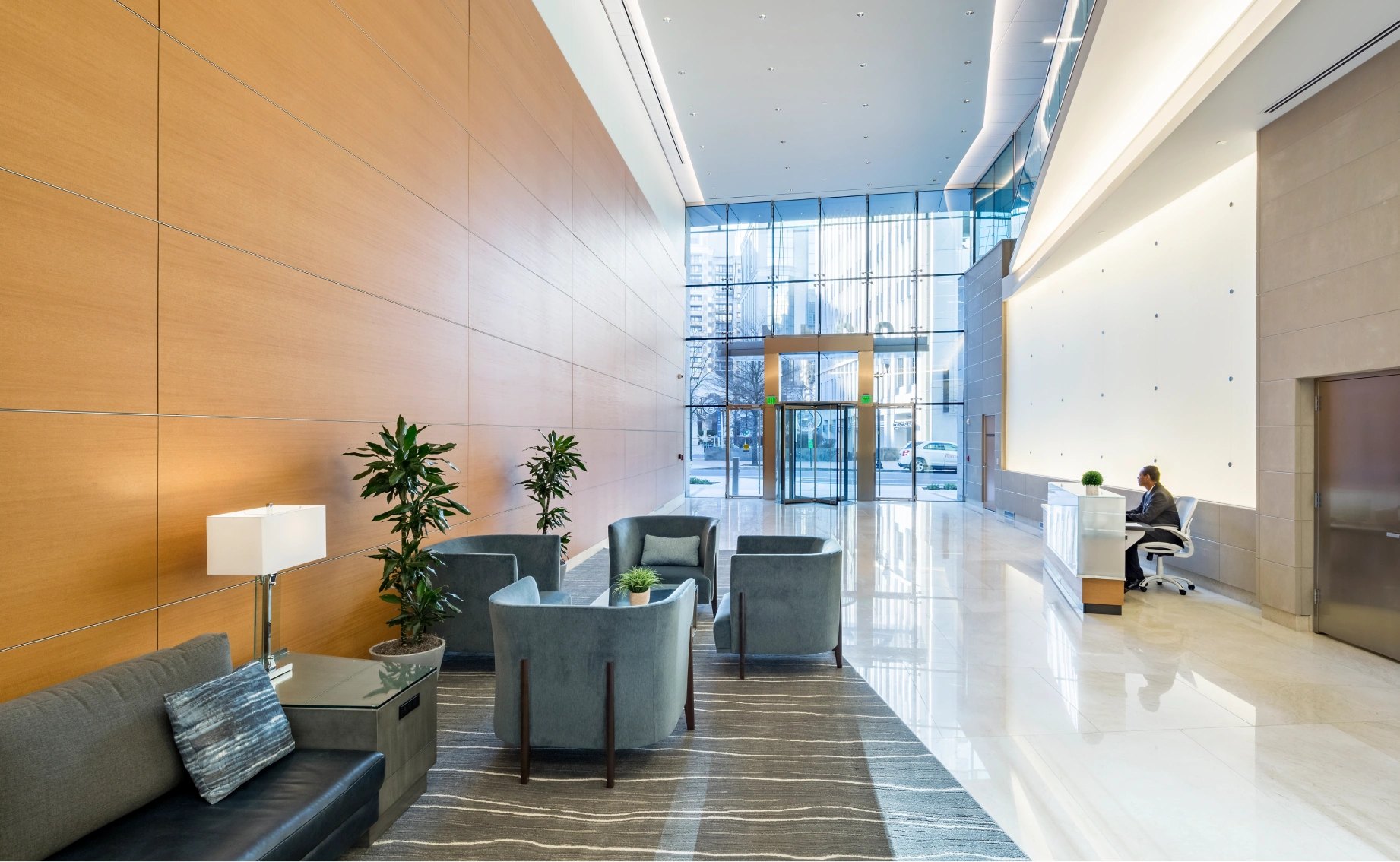 Elegant corporate reception area featuring a spacious lounge, polished floors, and floor-to-ceiling glass