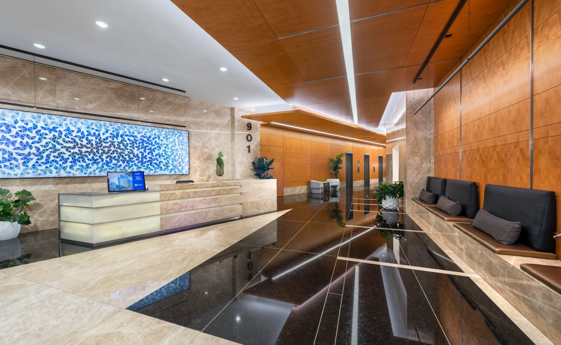 Corporate interior design with sleek lighting, marble surfaces, integrated seating, and a large abstract art installation