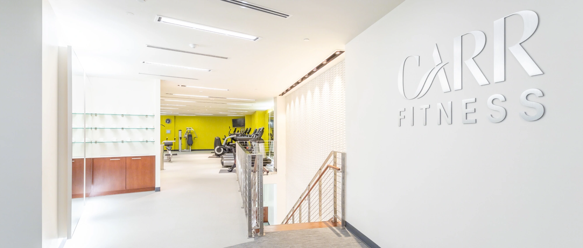 Upscale wellness and fitness space with minimalist design, ample lighting, and state-of-the-art exercise machines in the background