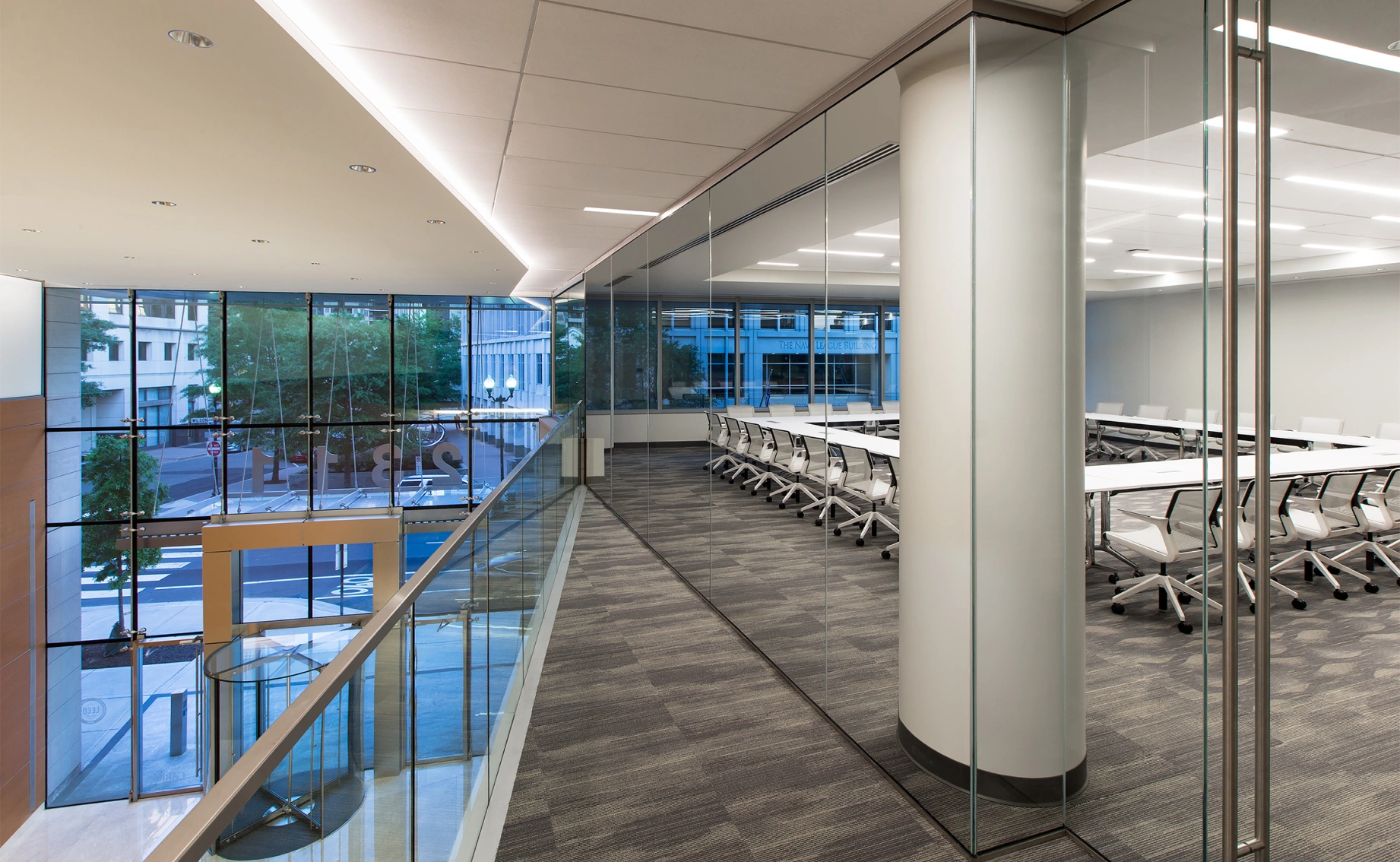 Contemporary workplace design featuring transparent meeting spaces, clean lines, and a bright, open layout