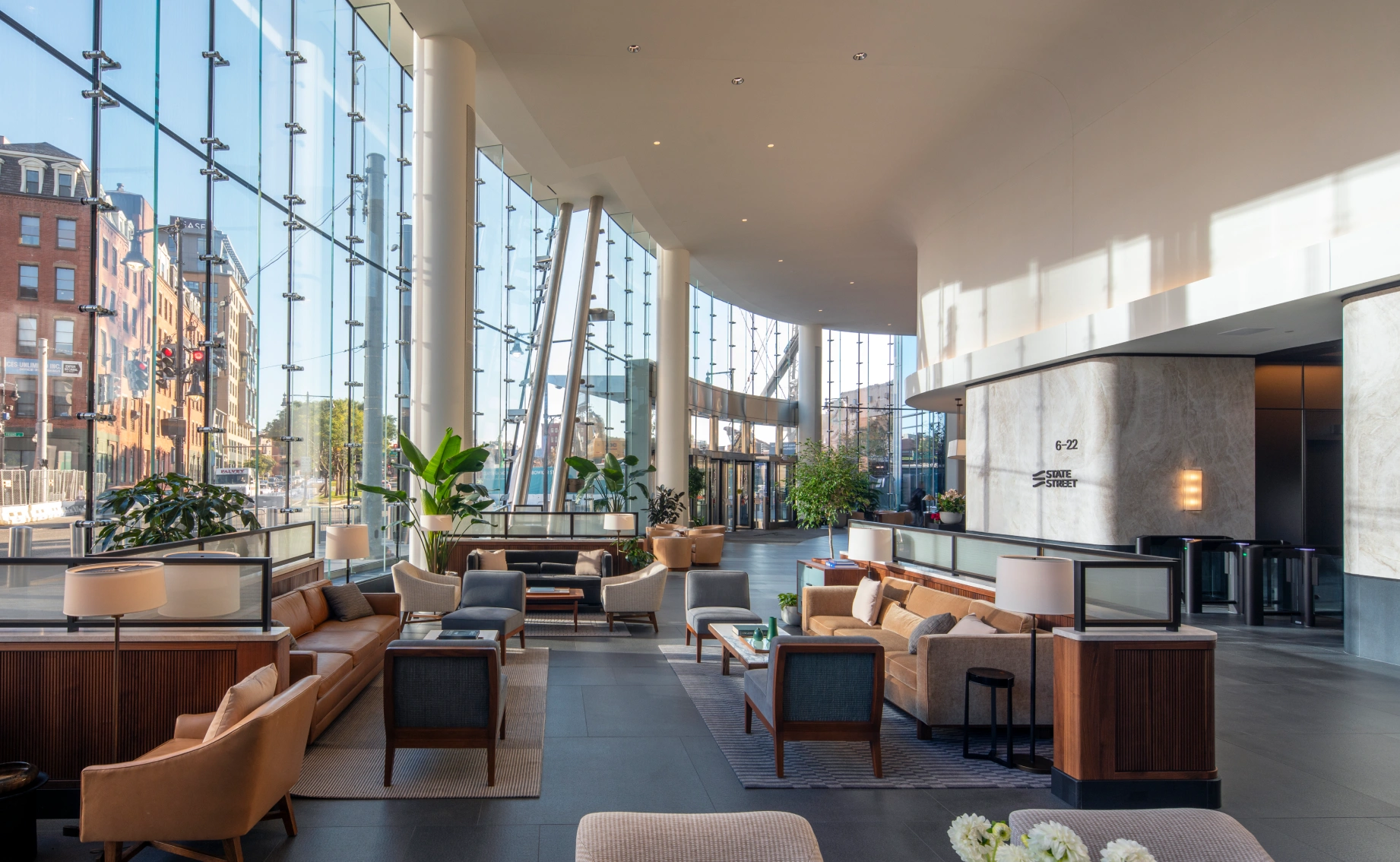 Contemporary office atrium at One Congress showcasing expansive glass façade, curated seating areas, and natural light