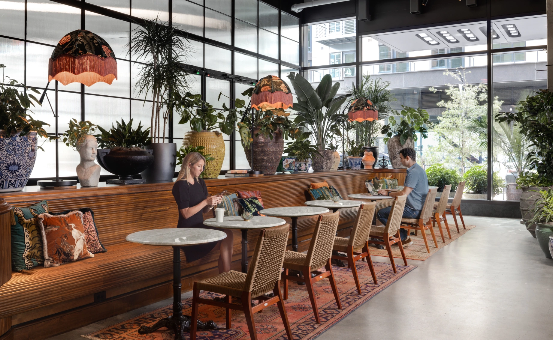 Inviting communal workspace or café interior highlighting greenery, soft lighting, and a relaxed atmosphere for working or casual conversation