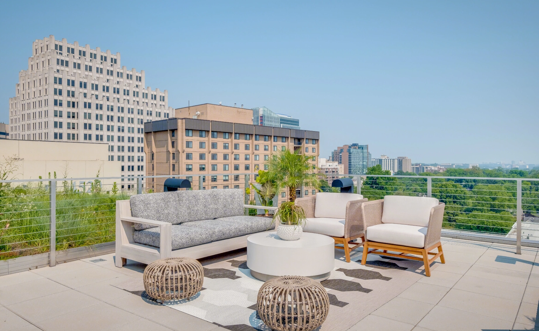 Modern rooftop lounge seating with sofas planters city skyline views and open air terrace