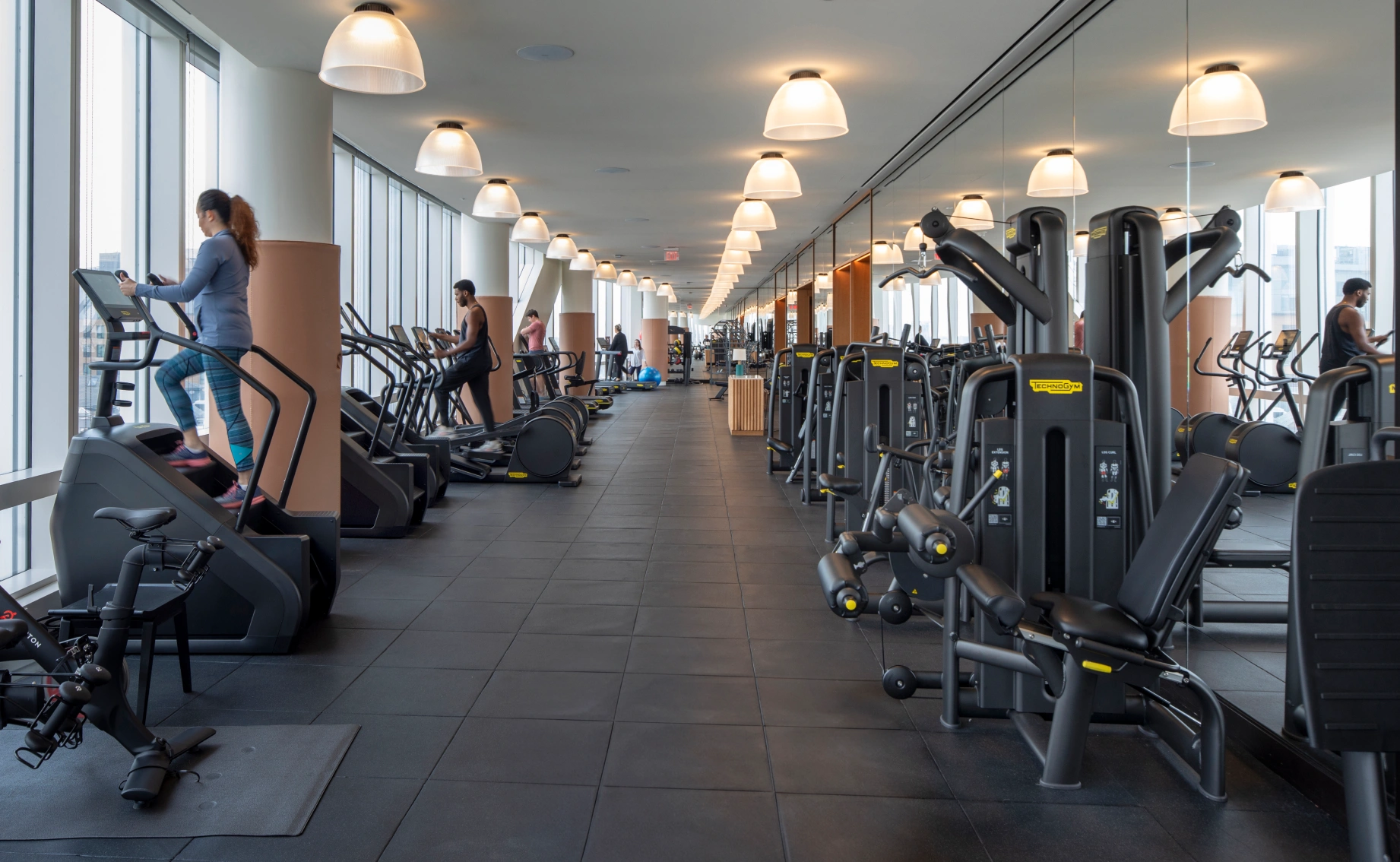Upscale workplace fitness facility showcasing a spacious layout, mirrored walls, and premium wellness amenities