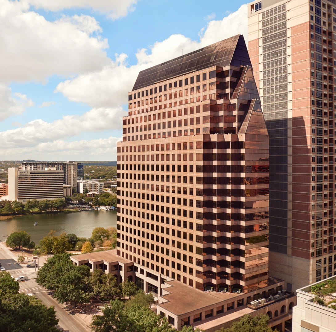 Modern commercial tower featuring geometric architecture, expansive windows, and prominent city skyline views