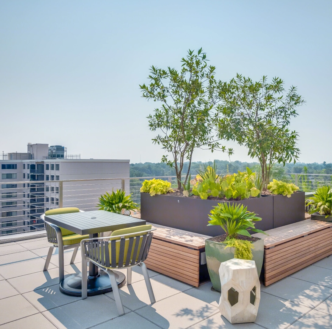 Modern rooftop terrace with outdoor seating, integrated planters, and panoramic city views