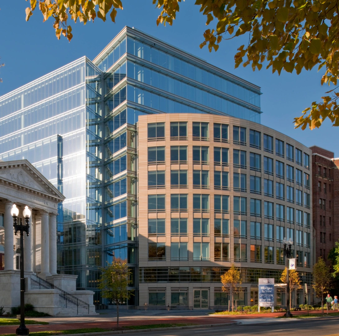 Modern commercial building combining transparent glass architecture with stone detailing and a prominent corner design