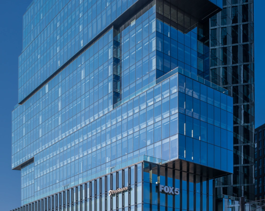 Contemporary high rise office building featuring blue glass curtain wall and geometric architectural form
