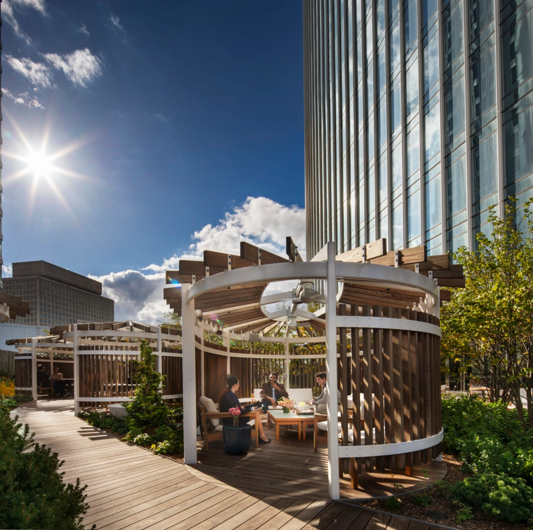 Rooftop-style urban garden featuring circular pergolas communal seating and surrounding city skyscrapers