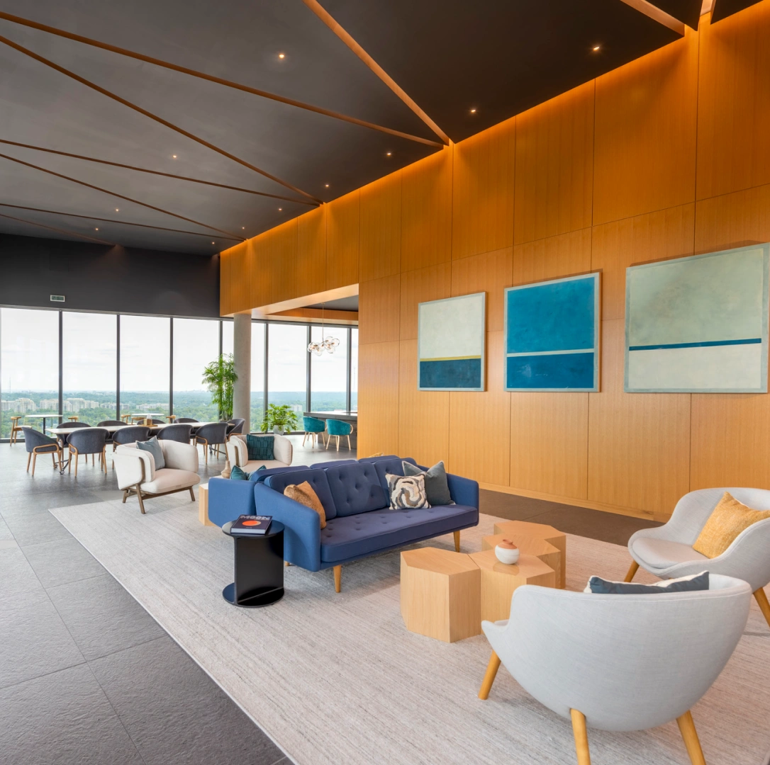 Modern office lounge with blue sofa contemporary seating wood panel walls and floor to ceiling windows