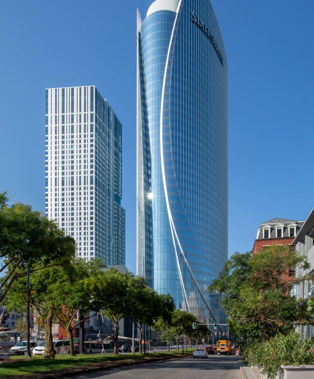 Contemporary high rise office tower with curved glass facade against clear blue sky
