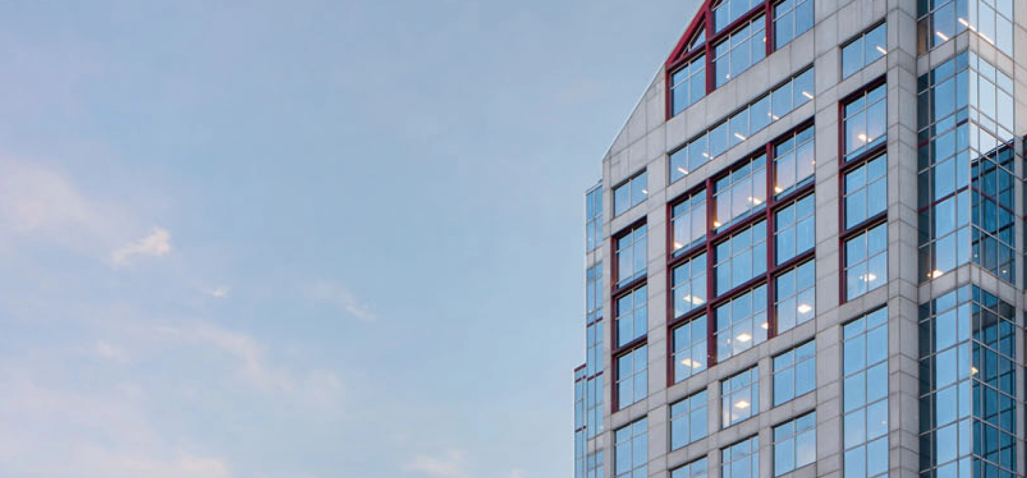 Contemporary commercial building façade featuring reflective glass panels and geometric architectural lines