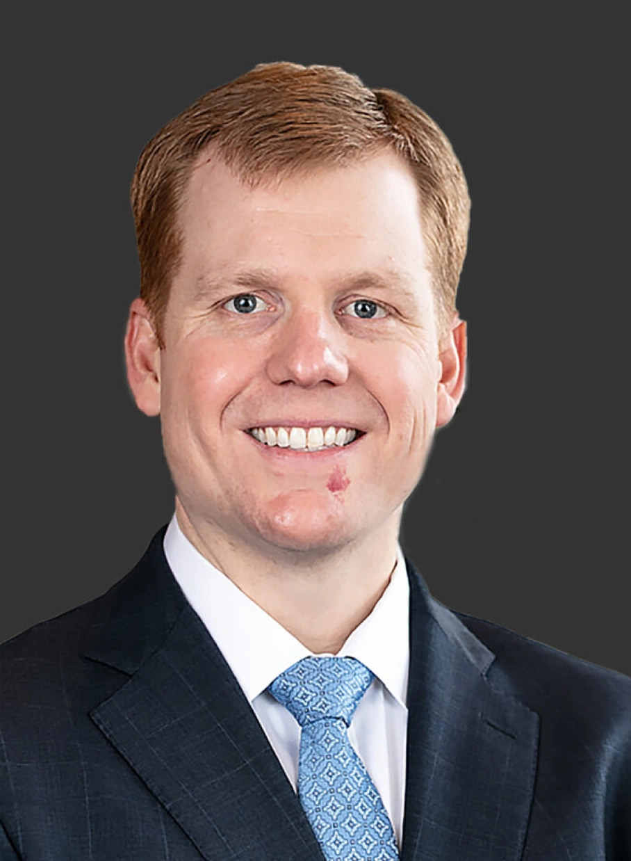Corporate leadership portrait featuring confident professional man with friendly smile and polished formal attire