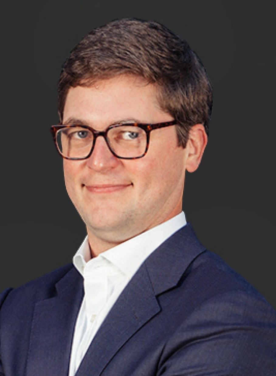 Corporate portrait featuring confident professional with short hair glasses and tailored blazer