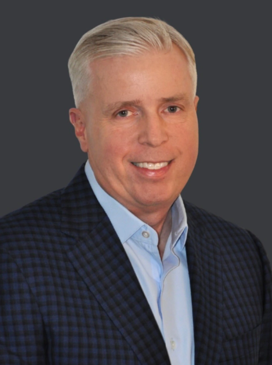 Corporate portrait of experienced business leader smiling confidently against neutral studio background
