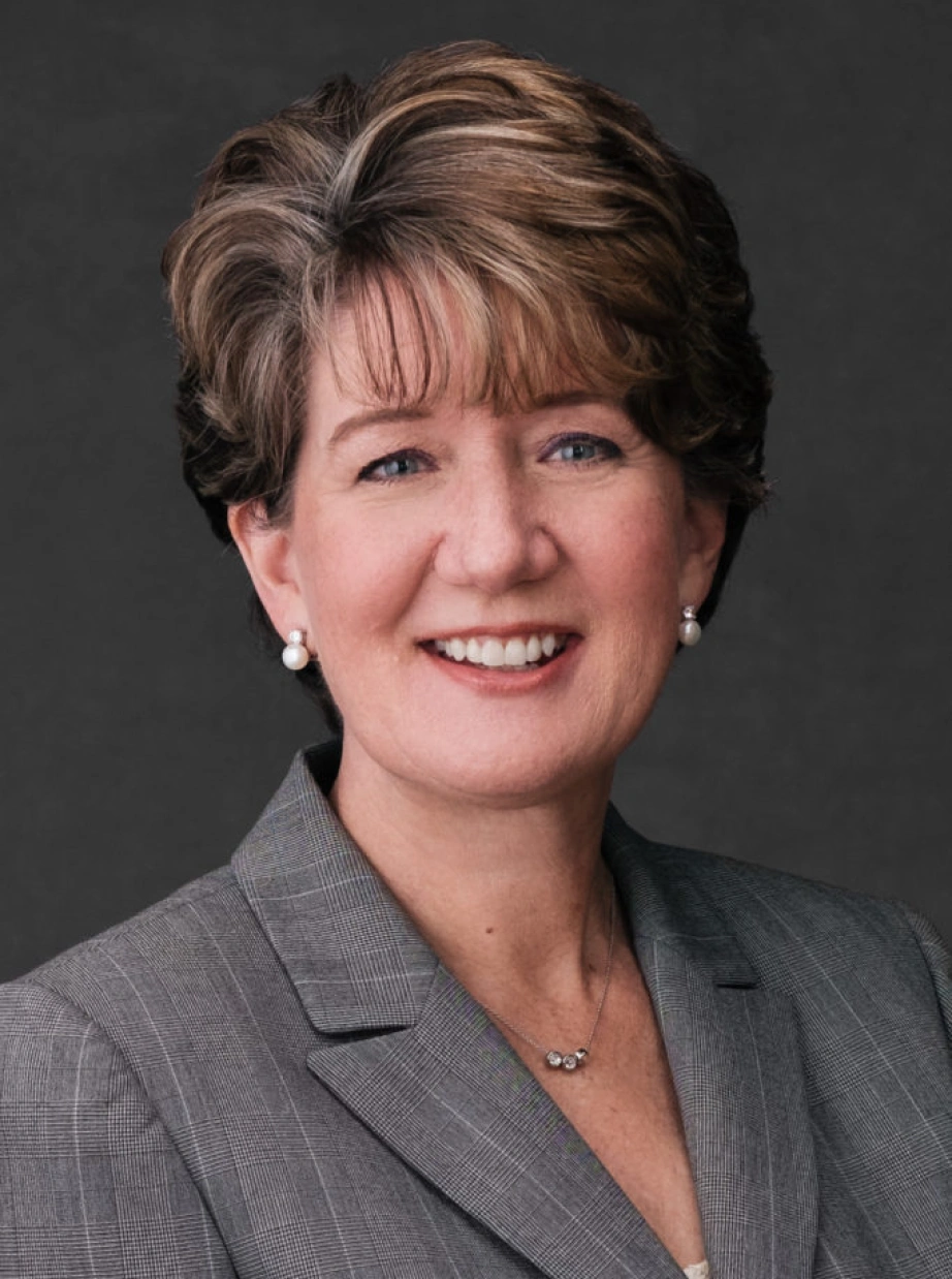 Corporate executive portrait featuring confident professional woman in tailored blazer with approachable expression