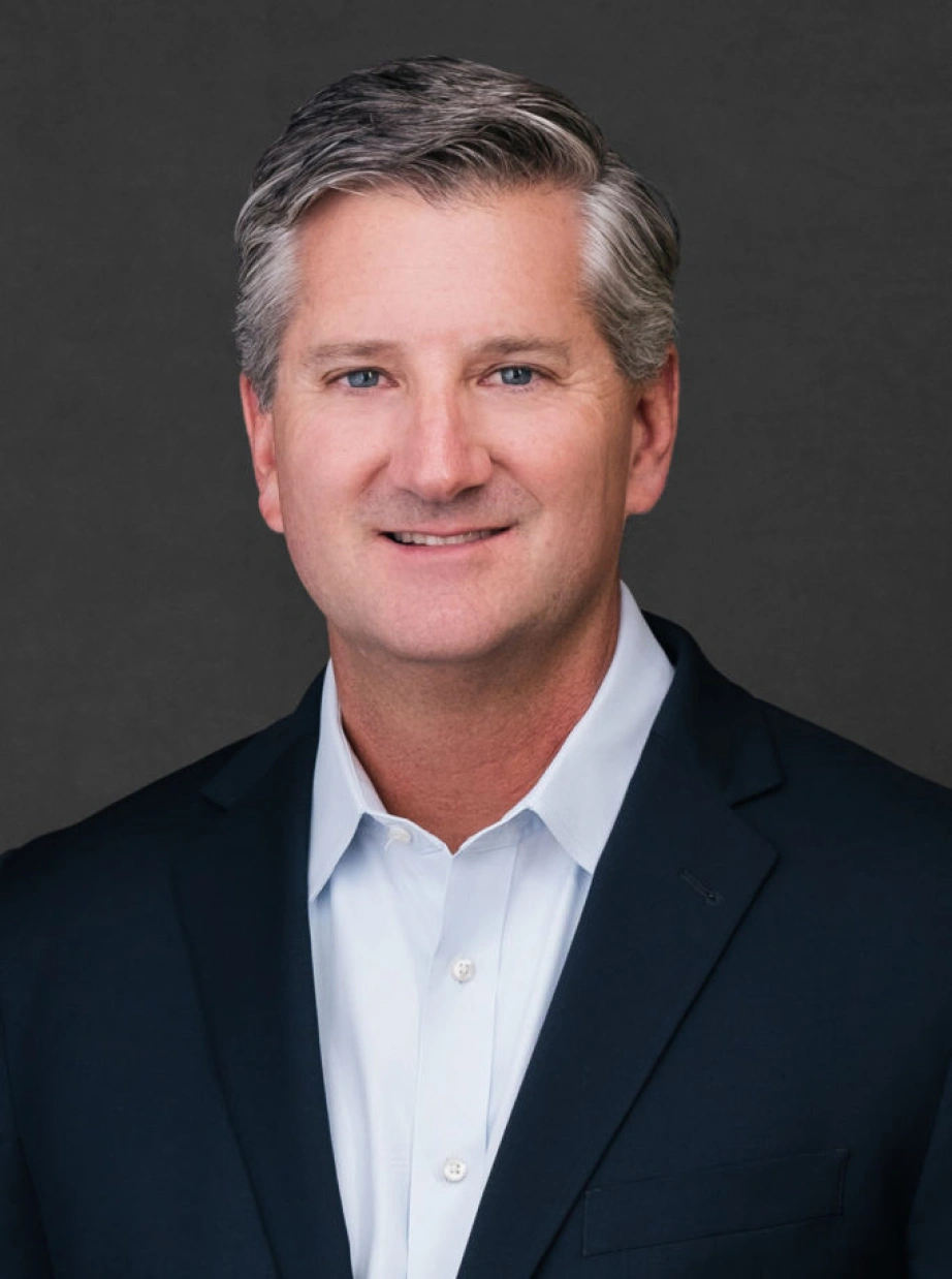 Corporate portrait of senior business leader with confident expression against neutral studio background