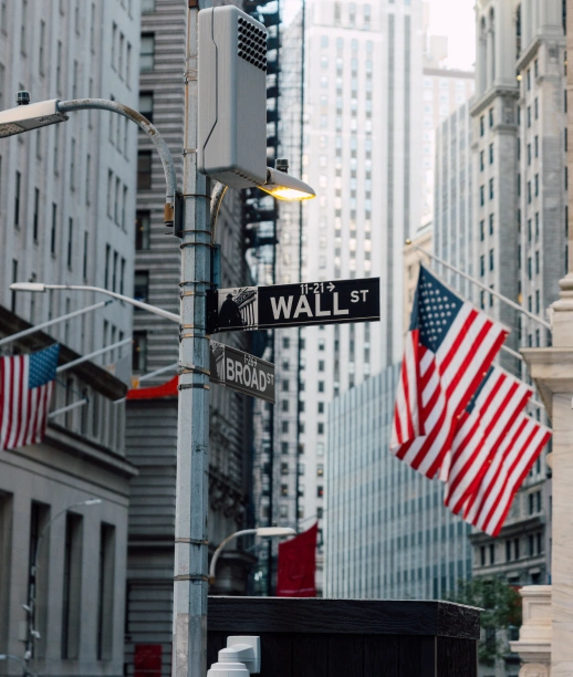 New York City Wall Street sign photographed in historic financial district with American flags displayed