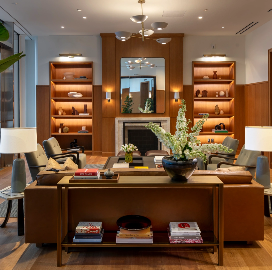 Modern corporate living room featuring fireplace curated decor soft lighting and upscale seating