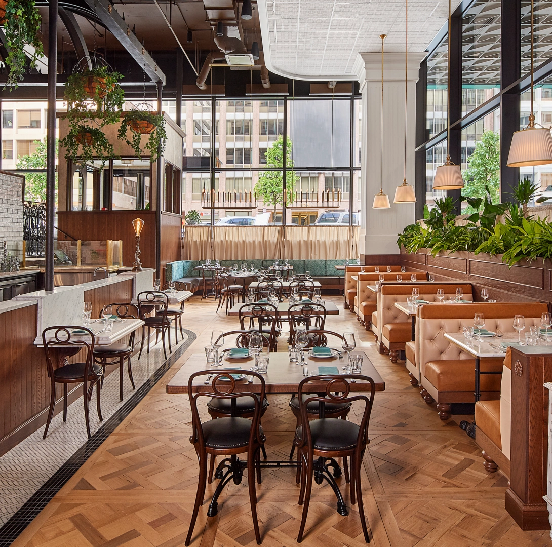 Elegant café style restaurant showcasing natural light, booth seating, and contemporary urban design