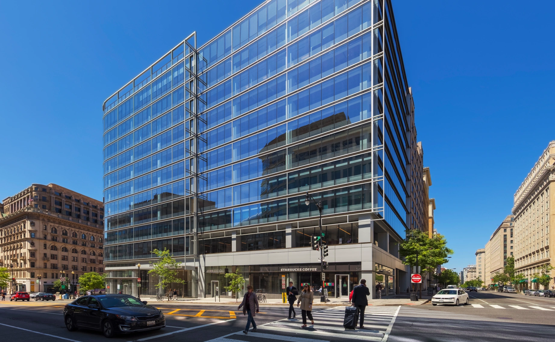 Contemporary downtown office building featuring reflective glass facade crosswalks and surrounding historic architecture