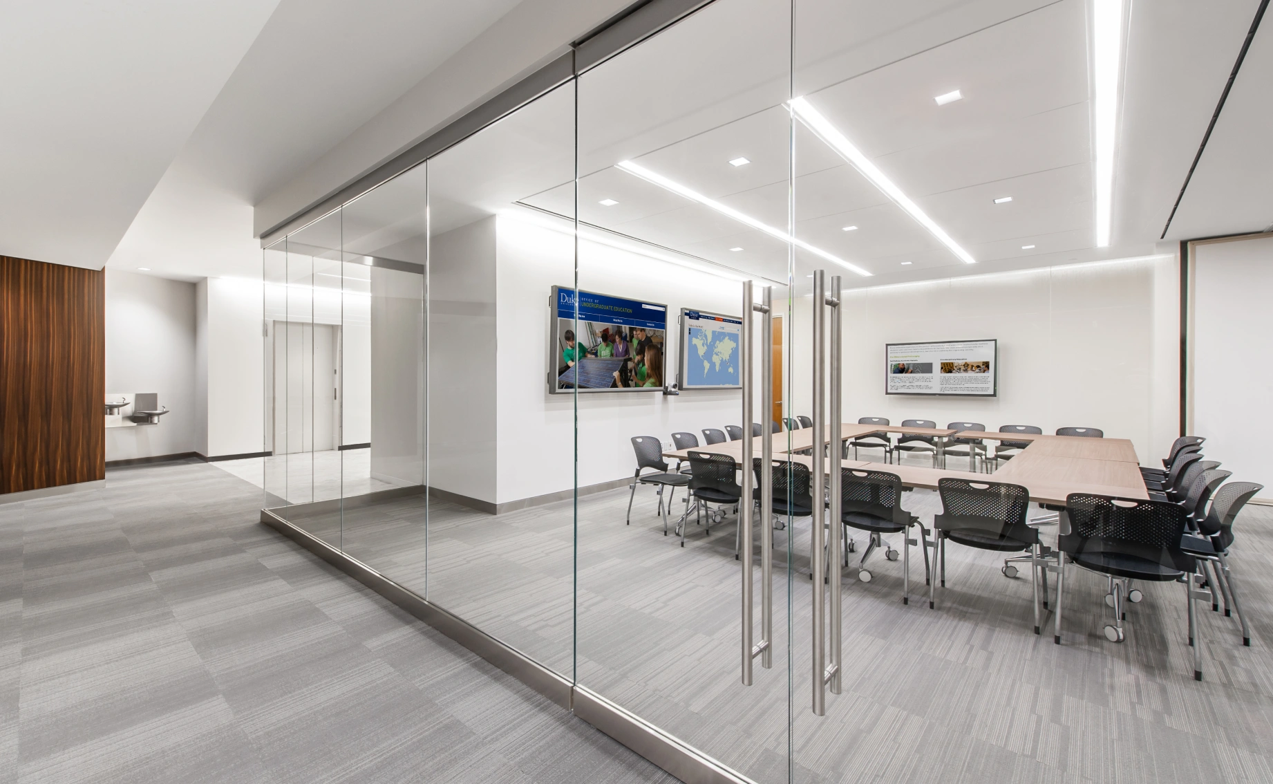 Professional training room with glass partitions conference tables ergonomic chairs and bright lighting